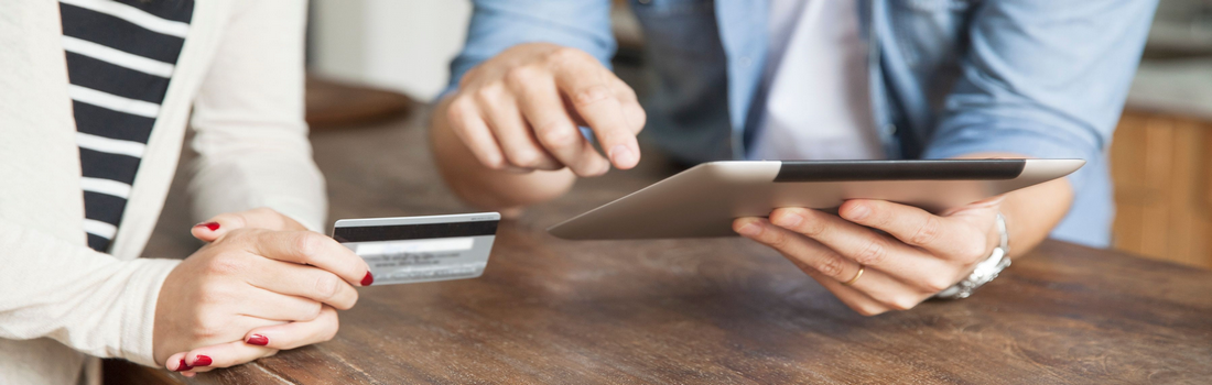 Man and woman are using tablets to make credit card payments.